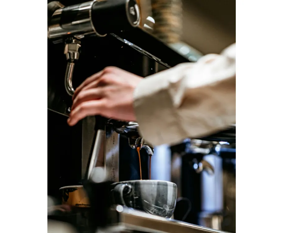 Barista macht Kaffee mit Espressomaschine.