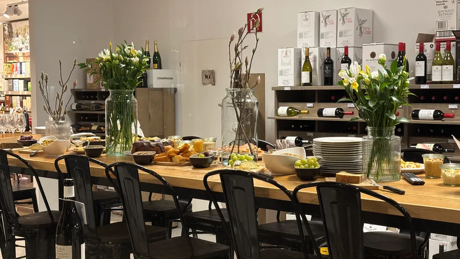 Tisch mit Essen und Blumen im Weinladen.