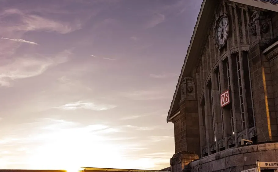 Train station building at sunset with clock.
