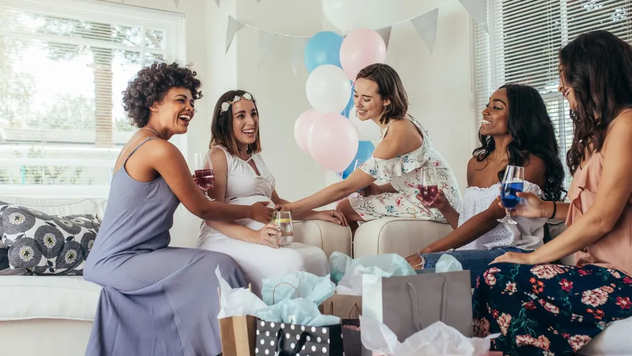 Women celebrating in living room with balloons.