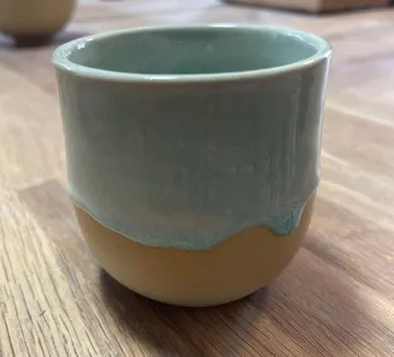 Keramiktasse auf einem Holztisch.