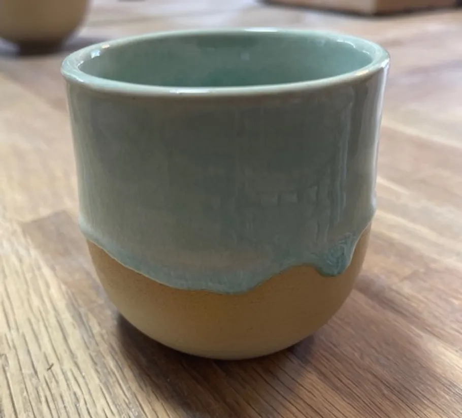 Keramiktasse auf einem Holztisch.