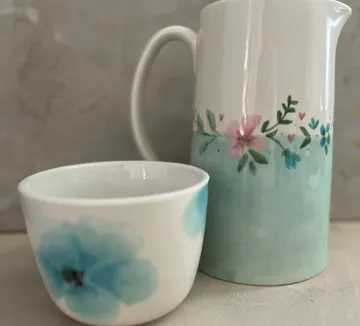 Ceramic mug and jug with floral designs.