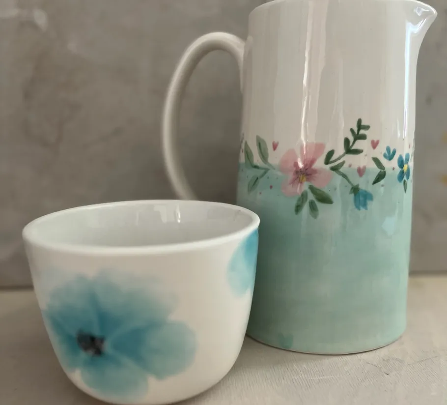 Ceramic mug and jug with floral designs.