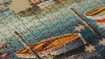 Partially completed puzzle with boats and water.