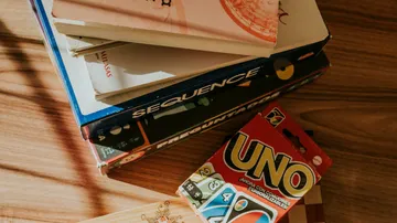 Stapel von Spielen und Büchern auf Tisch.