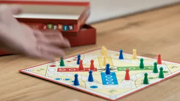 Board game with colored pieces on table.