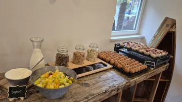 Frühstücksbuffet mit Früchten, Gläsern, Joghurt und Gebäck.
