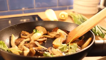 Pilze in einer Pfanne mit Kräutern gebraten.