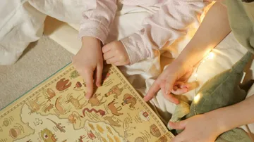 Kinder betrachten illustriertes Buch mit Karte.