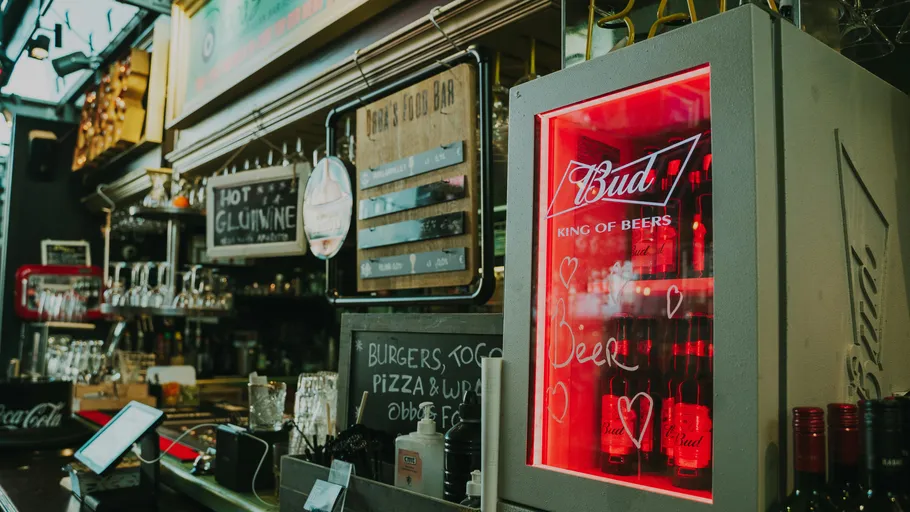 Bartheke mit Budweiser-Kühlschrank und Menütafel.