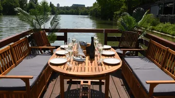 Elegant table set on dock overlooking a lake.