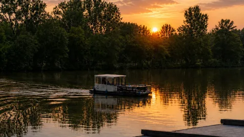 Boot fährt bei Sonnenuntergang auf einem See.