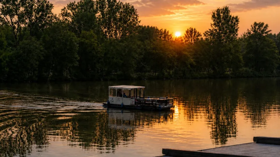 Boat sailing on a lake at sunset.