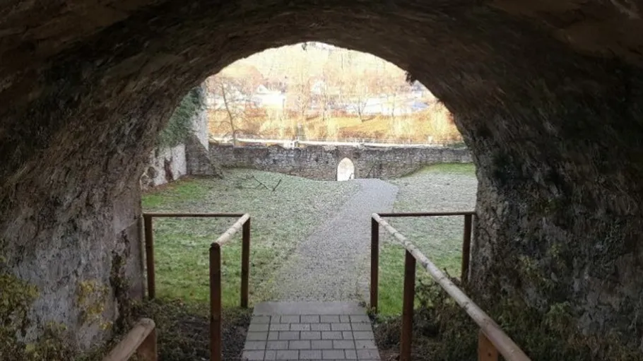 Steintunnel führt zu einem Außenhof.