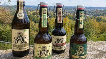 Vier Berg-Bierflaschen auf steiniger Oberfläche im Freien.