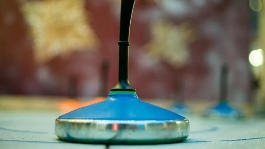Nahaufnahme eines Curlingsteins auf Eis.