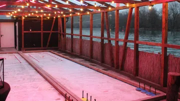 Außen-Eisstockbahn mit Lichterketten.