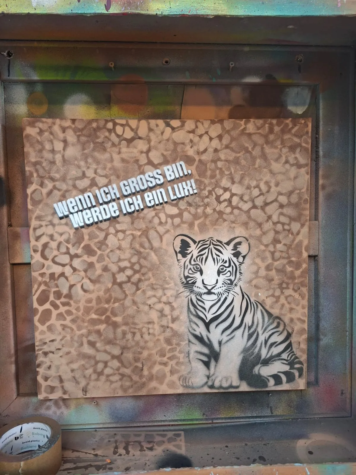 Schablonen-Tigerjunges mit humorvollem Text im Graffiti-Stil.