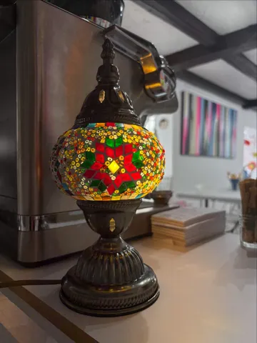 Bunte Mosaiklampe auf Café-Tresen.