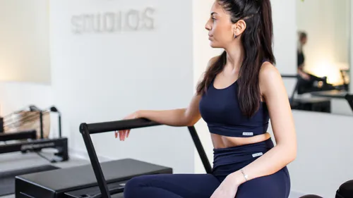 Eine Frau auf dem Pilates Reformer