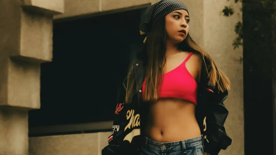 Woman wearing pink top and beanie outside building.