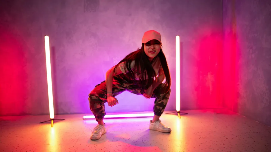Tänzerin posiert mit bunten Lichtern im Studio.
