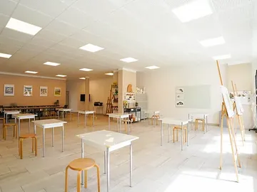 Empty tables and chairs in bright art class.