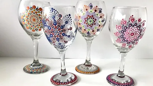Four wine glasses with colorful dot patterns.