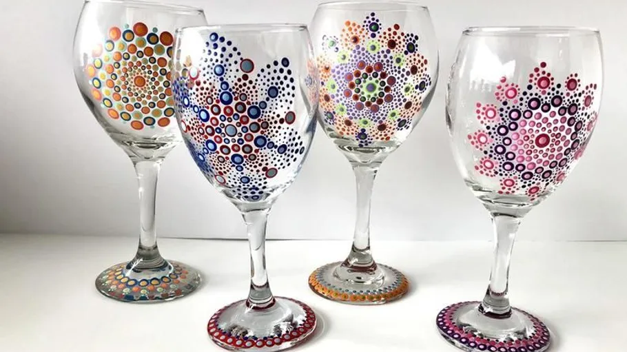 Four wine glasses with colorful dot patterns.
