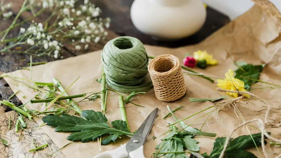 Bastelmaterial auf Papier mit Blumen.