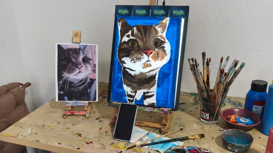 Katzenporträt auf Leinwand neben Referenzfoto.