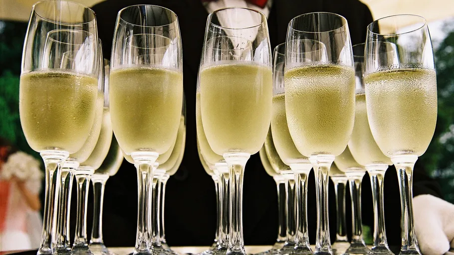 Champagne glasses lined on a tray.