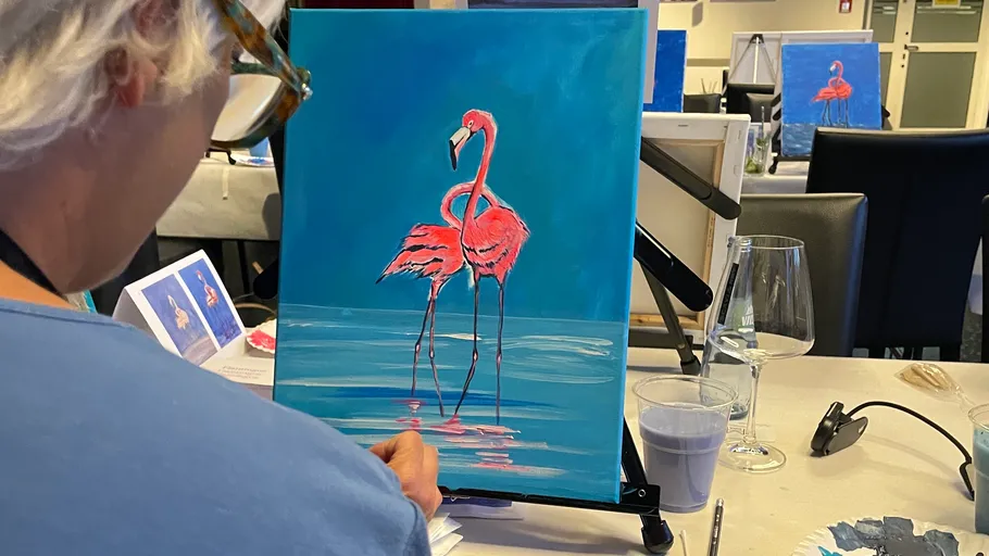 Person malt einen Flamingo in einem Kunstkurs.