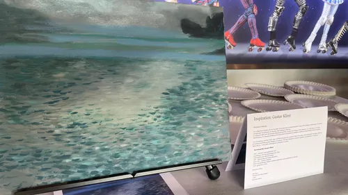 Painting of sea on display with text description.