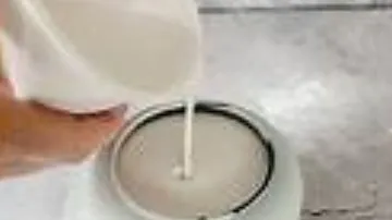 Person pouring liquid into an air fryer.