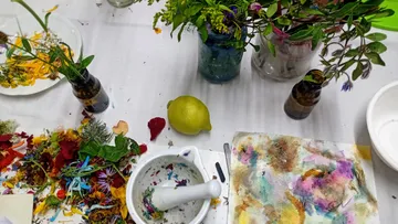 Flowers and tools on a cluttered table.