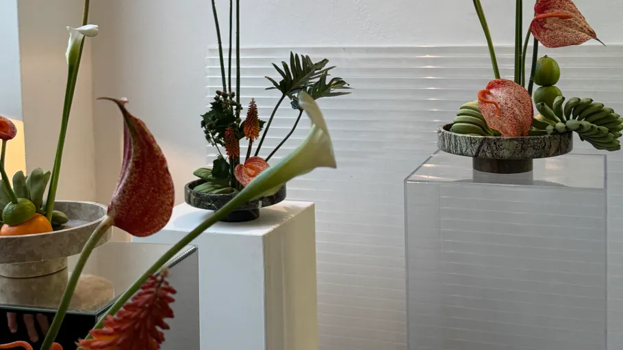 Elegante Blumenarrangements auf modernen Sockeln innen.