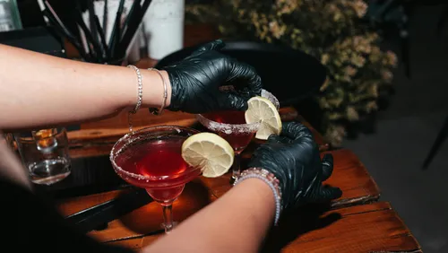Bartender garnishes cocktails with lemon slices.
