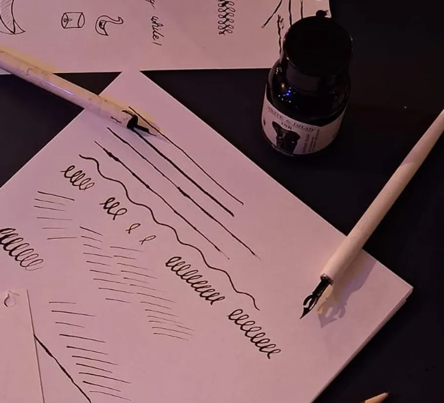 Calligraphy practice with ink and pens on paper.