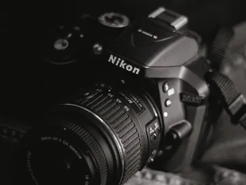 Kamera liegt ruhig auf dunklem Untergrund, Nikon-Logo sichtbar.