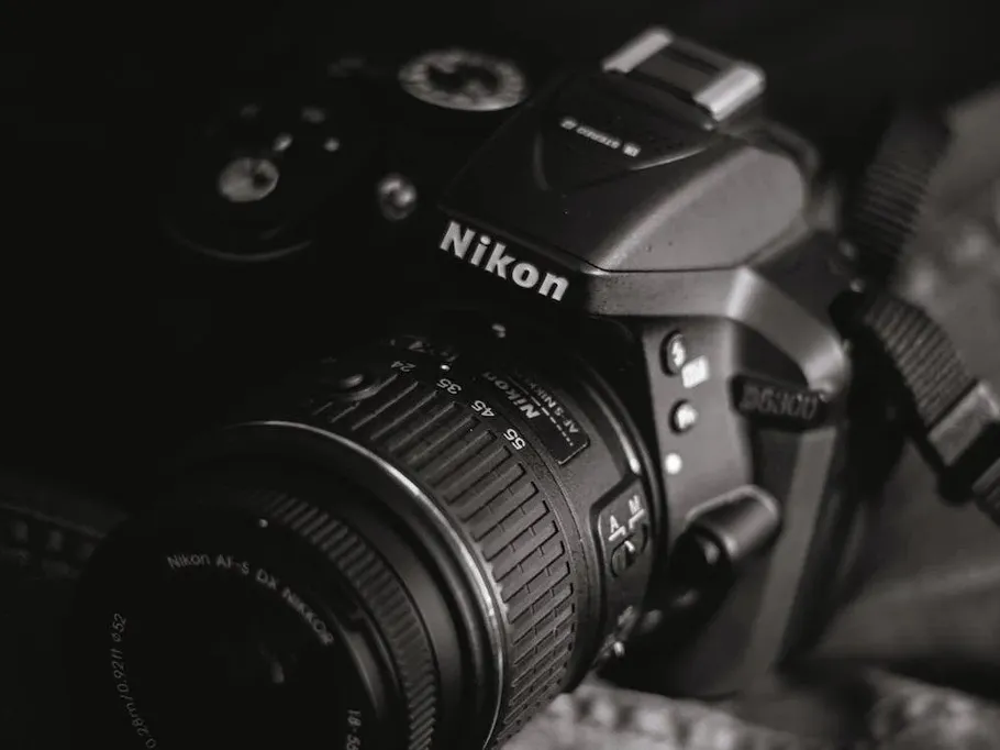 Camera lies quietly on dark ground, Nikon logo visible.