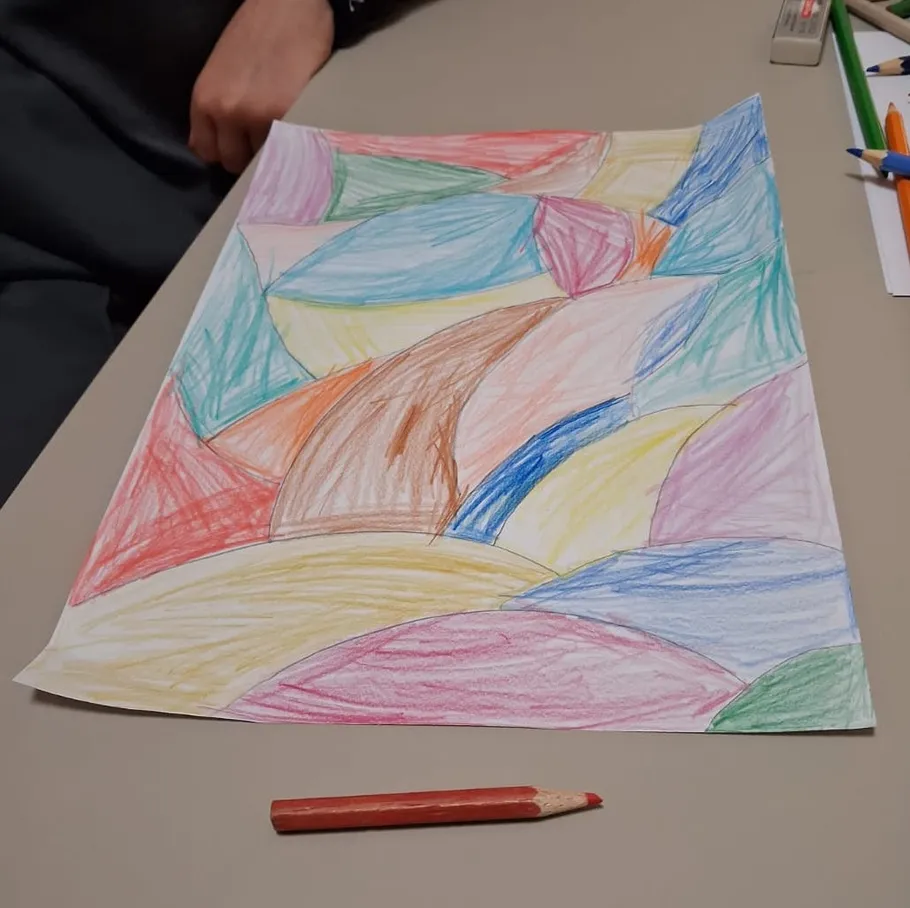 Colorful abstract drawing on table with pencils.