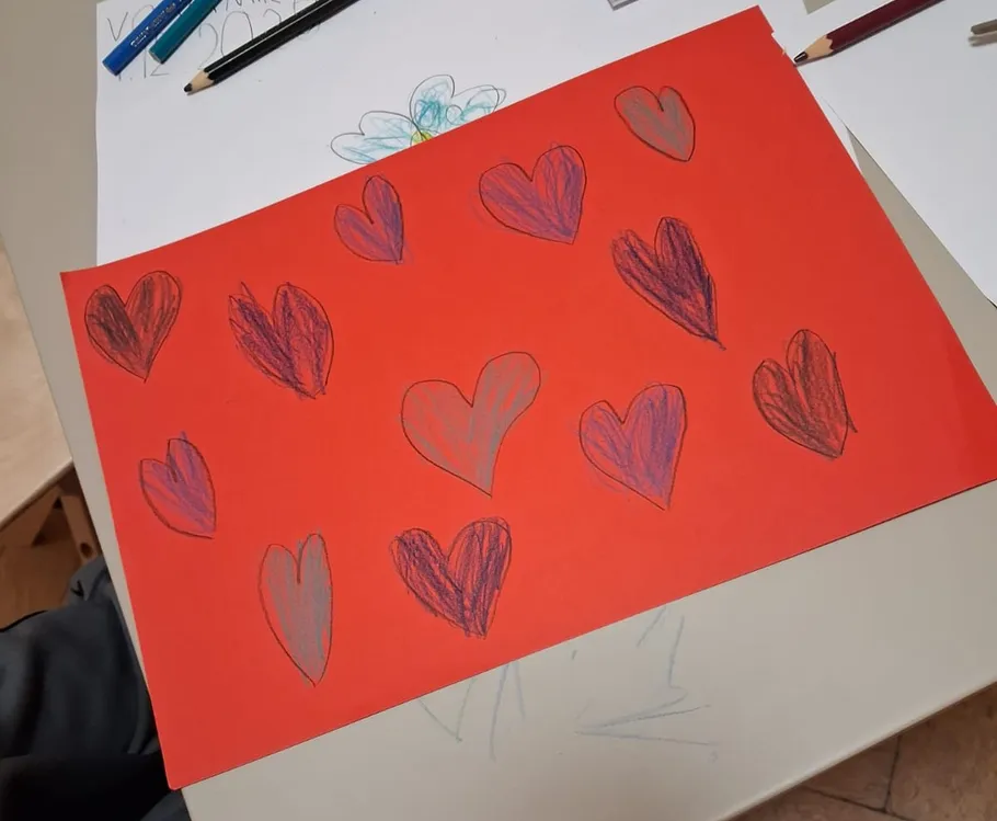 Red paper decorated with hand-drawn hearts.