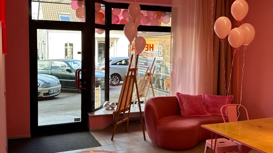 Zimmer mit rosa Ballons und Sitzbereich, Straßenblick.