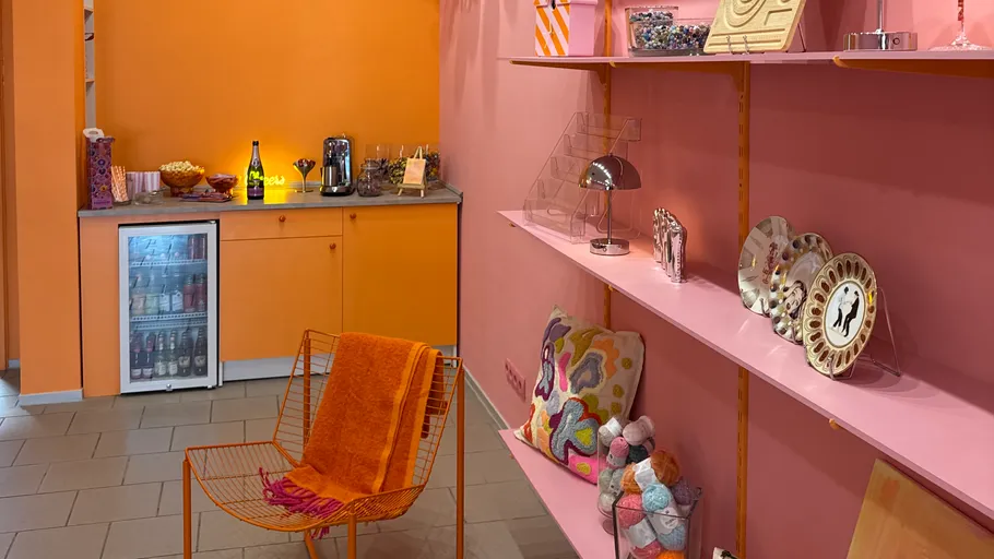 Colorful room with orange chairs and shelves.
