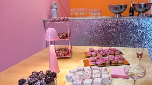Desserts and pink decorations on a table.