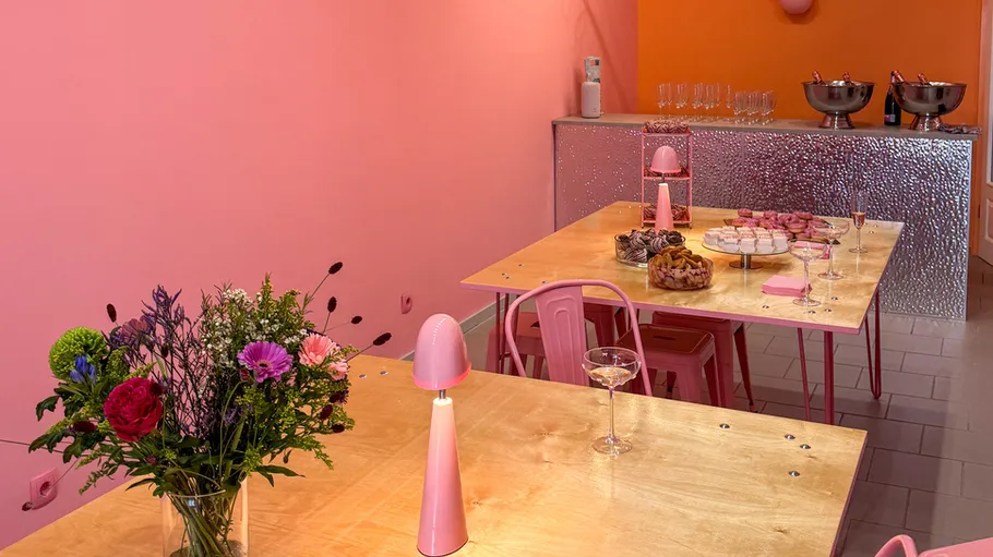 Colorful room with tables, flowers, and snacks.