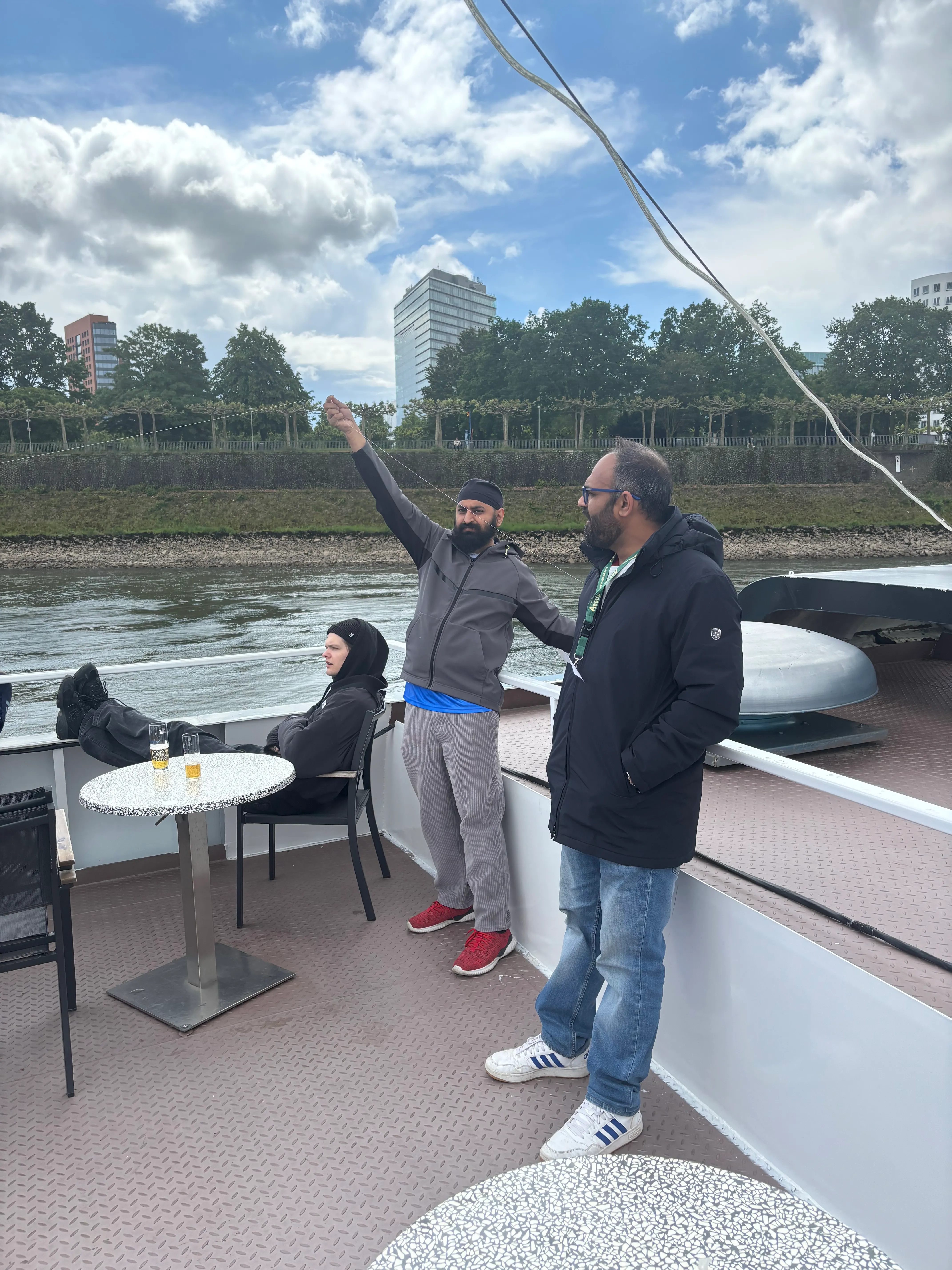 People relaxing on boat, riverbank in background.
