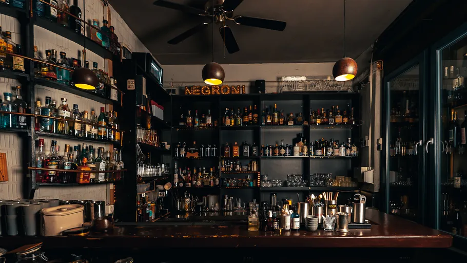 Bar mit Regalen voller Schnapsflaschen.